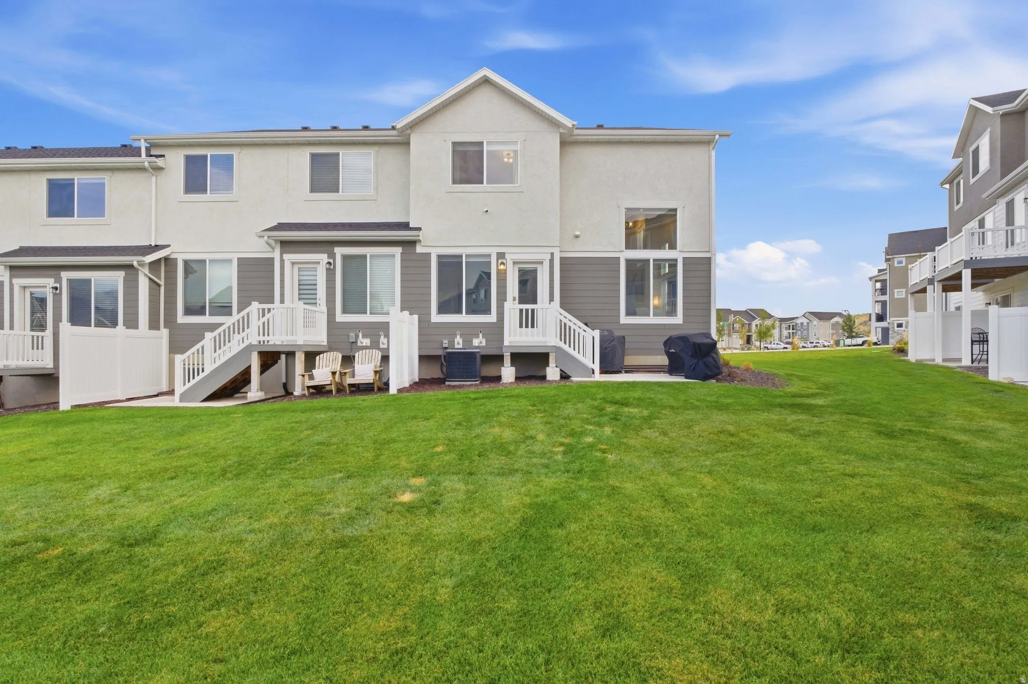 Rear elevation featuring a stucco and siding exterior, private deck, and ground-level patio