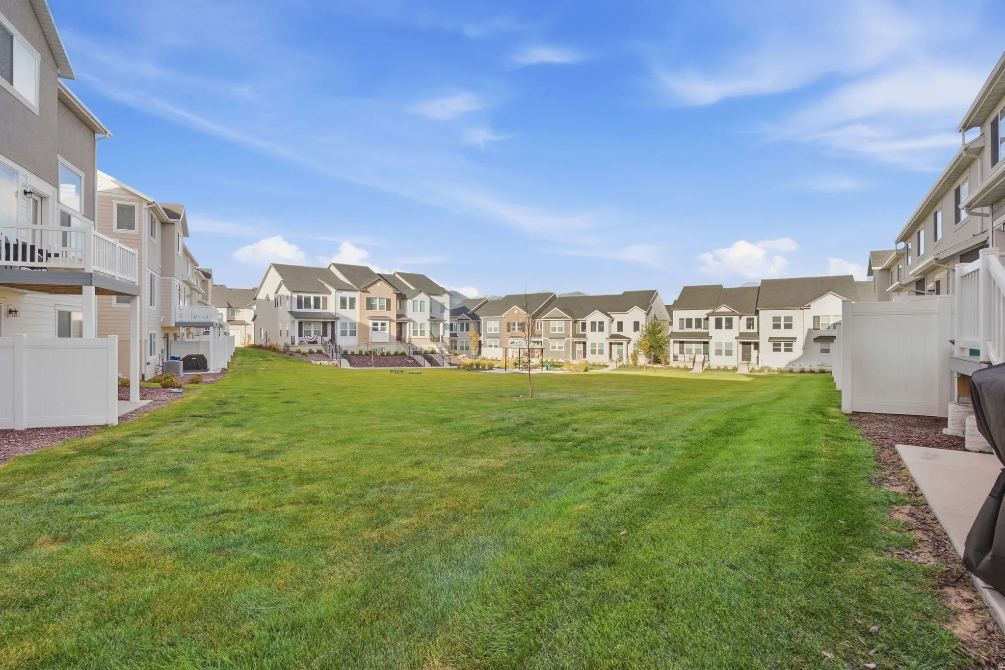 Expansive green space, surrounding residential structures, and private fencing