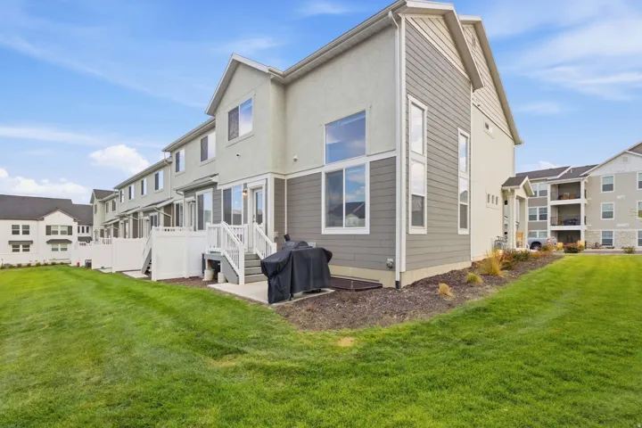 Expansive green space with an exterior featuring siding and stucco finishes