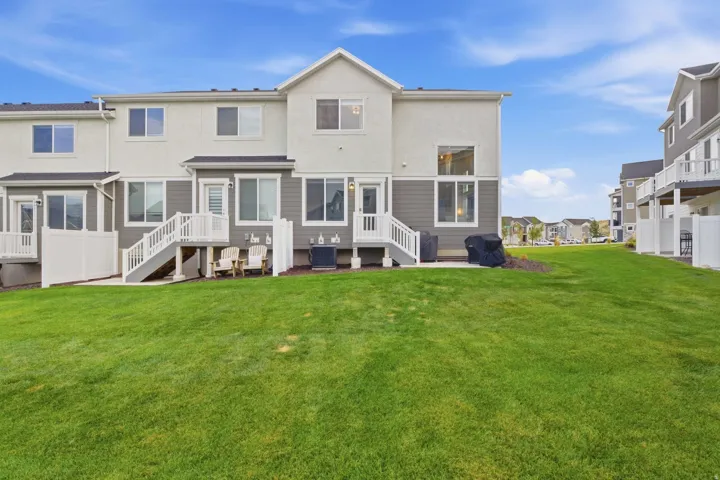 Rear elevation featuring a stucco and siding exterior, private deck, and ground-level patio