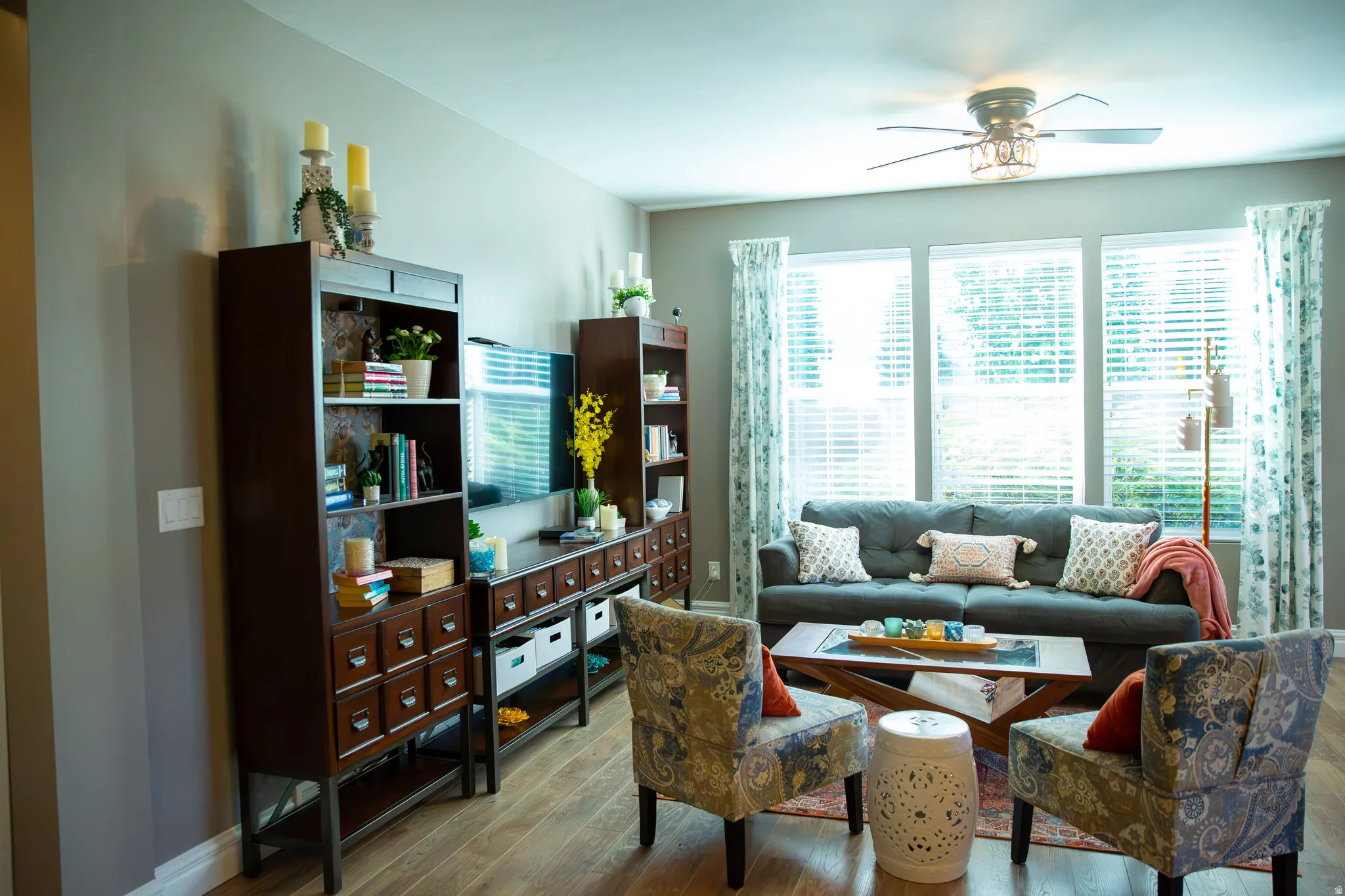 Wood-finish flooring throughout, light-toned walls, and a ceiling fan with integrated lighting
