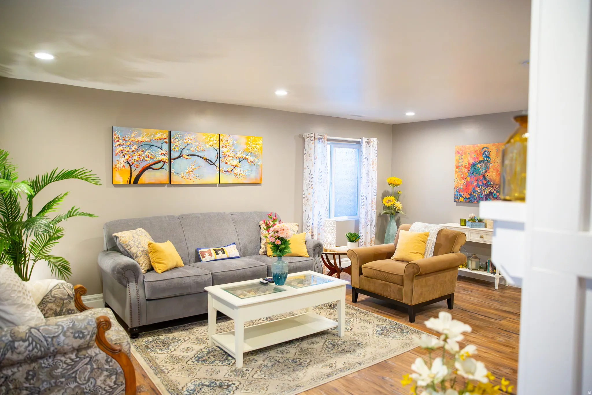 Recessed lighting with a flat ceiling, light gray wall paint, wood-finish flooring, and a white-trimmed window
