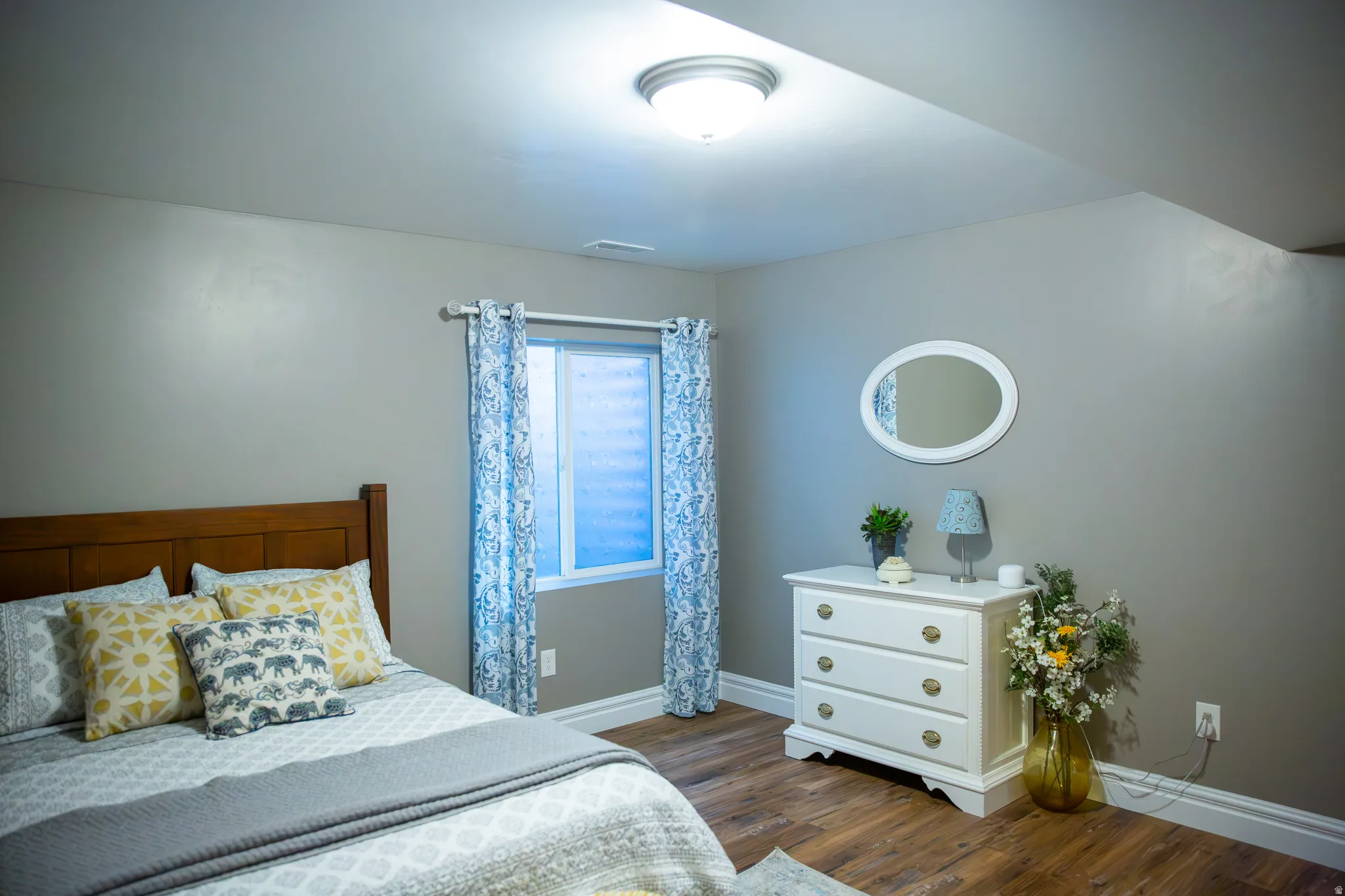 Wood-finish flooring, recessed window, white baseboards, flush mount ceiling light, and neutral wall paint
