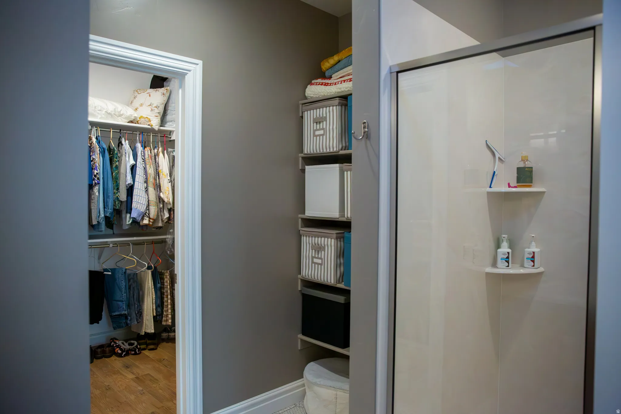 Walk-in closet with wood-finish flooring and dual-level hanging rods