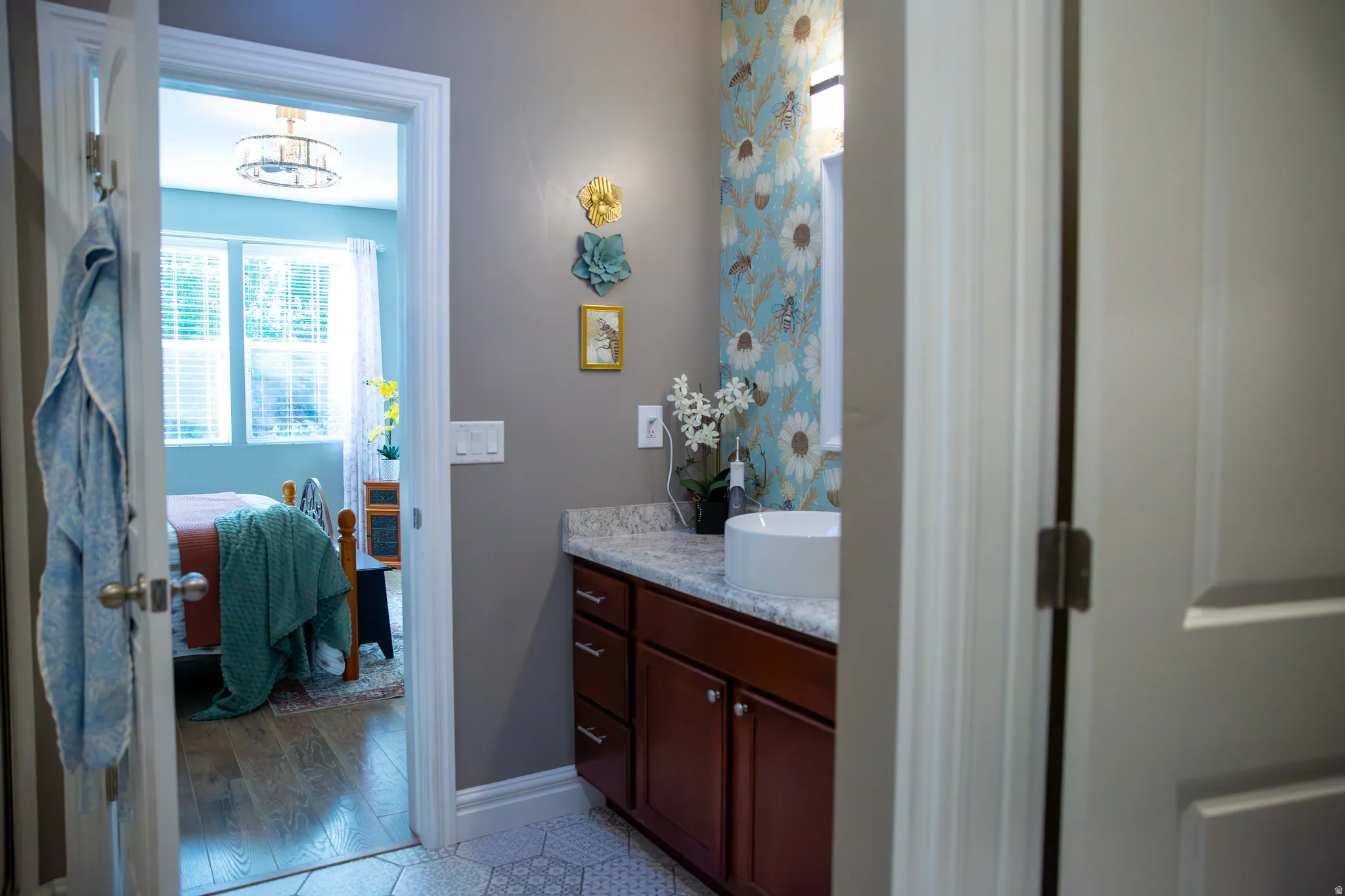 Vanity with stone countertop, vessel sink, and wood-finish cabinetry