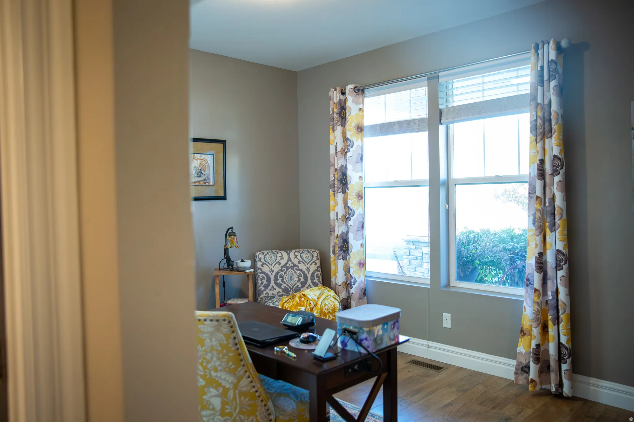 Recessed lighting, wood-finish flooring, two large windows, white window trim, and neutral wall paint