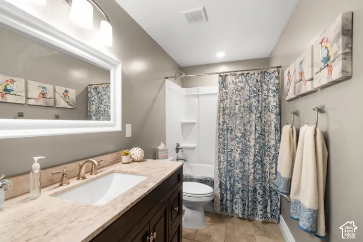 Bathroom featuring a vanity with an undermount sink, a countertop, and a framed mirror