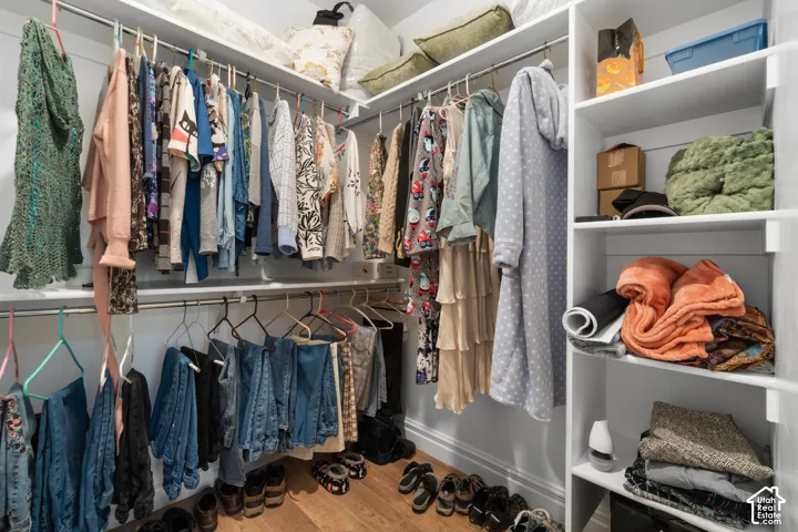 Built-in closet system with multiple hanging rods, corner shelving, and upper storage shelves
