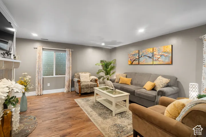 Recessed lighting, wood-finish flooring, and a window with privacy glass enhance this living space