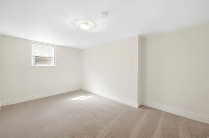 Carpeted flooring, recessed window, flush mount ceiling light, and vertical wall paneling