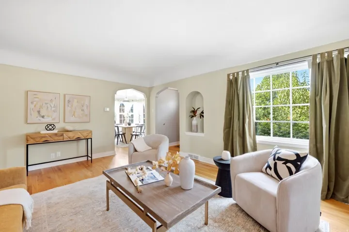 Hardwood flooring throughout, arched doorways, built-in wall niche, recessed window with grid muntins, and crown molding