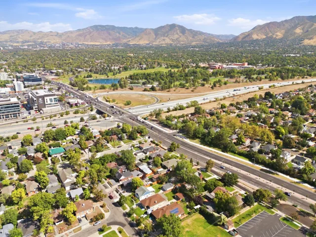 Expansive residential area with established homes, mature trees, and a mountain backdrop