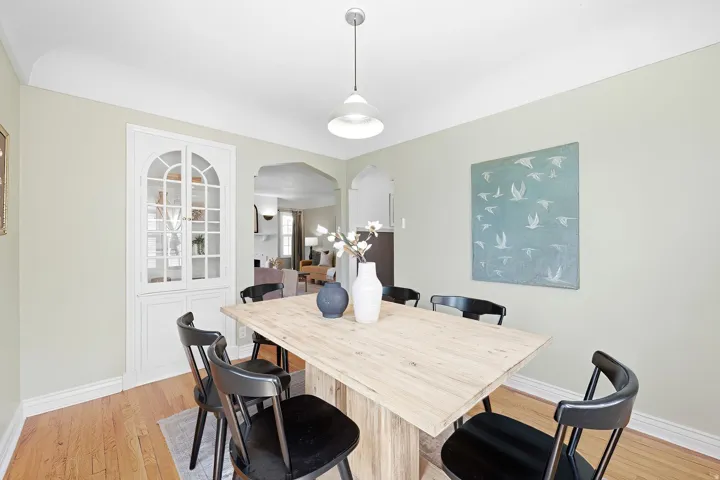 Hardwood flooring, arched built-in cabinetry, recessed archway, and pendant lighting