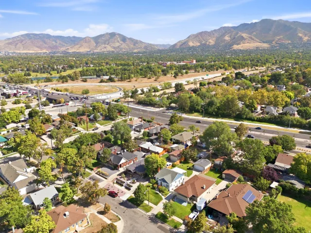 Residential neighborhood with mature trees, established properties, and distant mountain backdrop