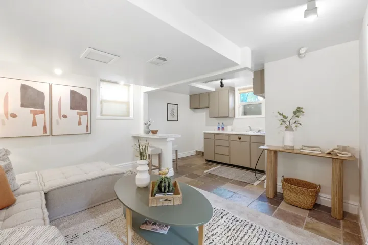 Compact kitchen area with light-toned cabinetry, a white sink, and a bar-height counter