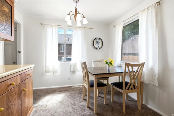 Recessed lighting, wood cabinetry with yellow hardware, and a semi-flush mount chandelier