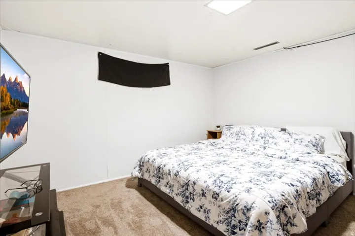 Wall-mounted television, recessed ceiling light, and carpeted flooring