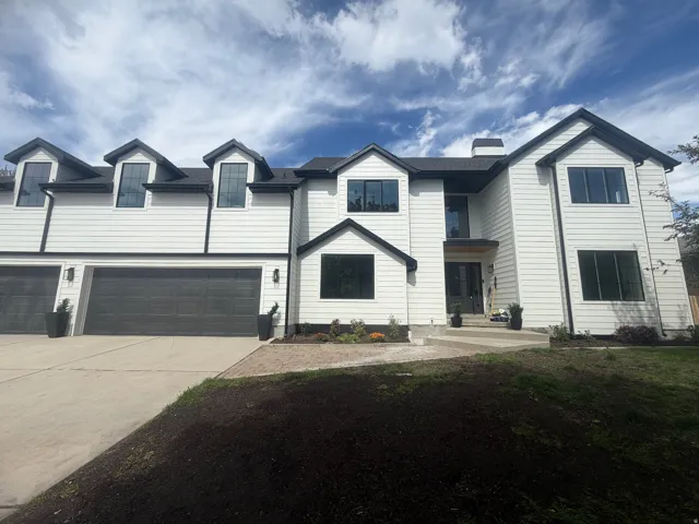 Contemporary exterior with white siding and black trim accents