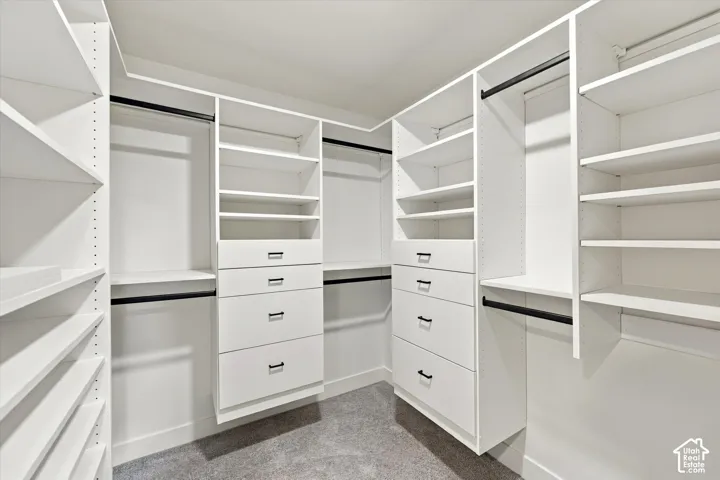 Custom built-in closet system featuring white shelving, integrated drawers with dark hardware, and multiple hanging rods