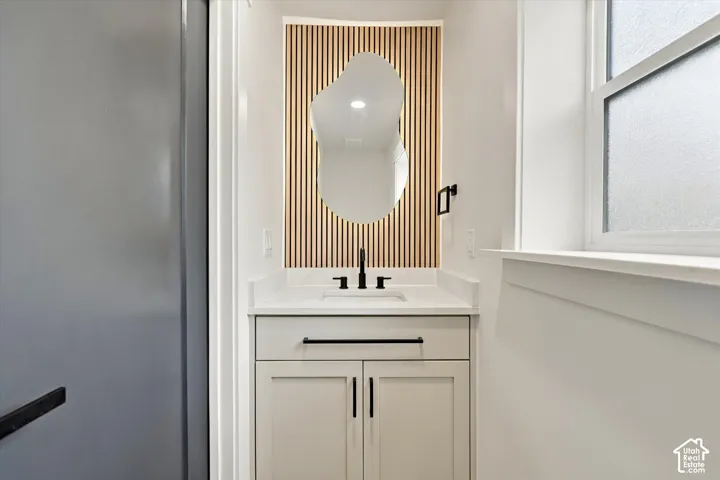 Vanity with a white countertop, under-mount sink, and matte black faucet