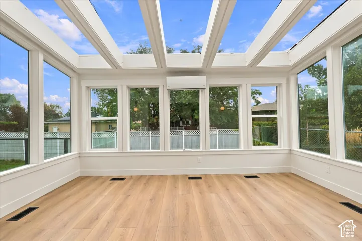 Sunroom with extensive glass paneling and a skylight roof