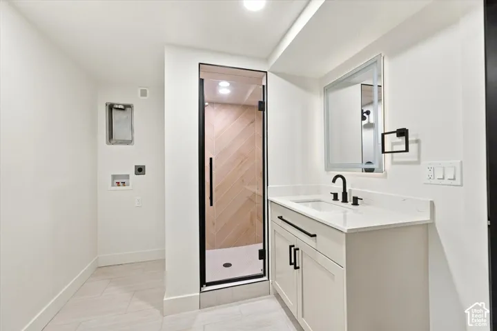 White vanity with a solid surface countertop, undermount sink, and matte black fixtures