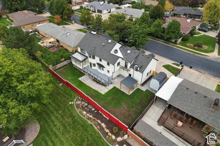 Well-maintained property featuring a gray shingle roof, white exterior siding, expansive rear deck, and a detached shed