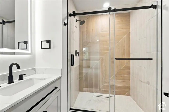 Walk-in shower with a glass enclosure and wood-finish tile accents