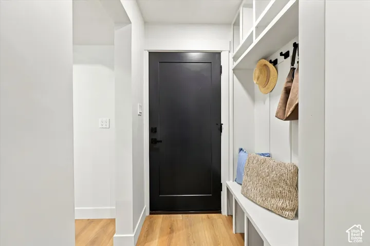 Built-in mudroom features shelving, bench seating, and wall-mounted hooks