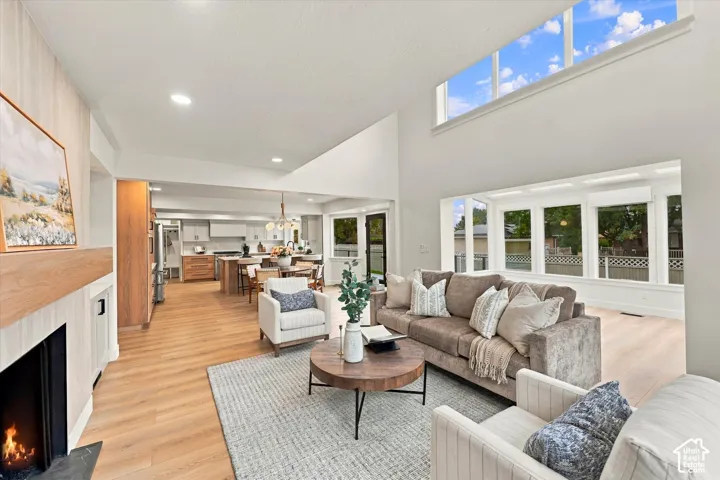 Vaulted ceilings with clerestory windows, wood-finish flooring, a built-in fireplace, and an open-concept layout
