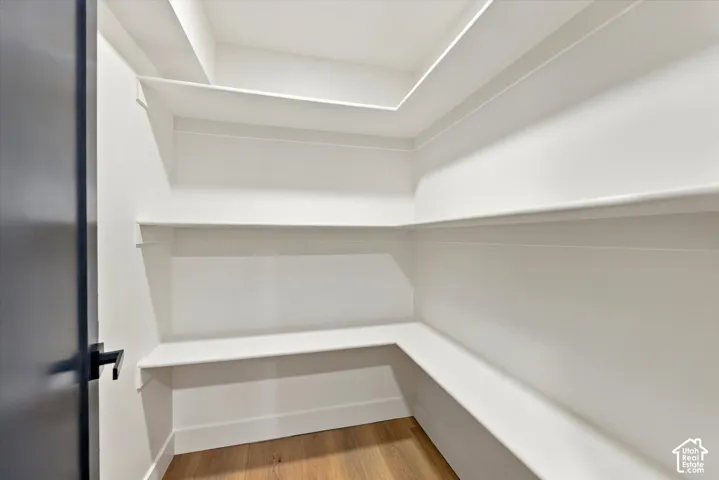 Built-in shelving, white walls, and wood-finish flooring