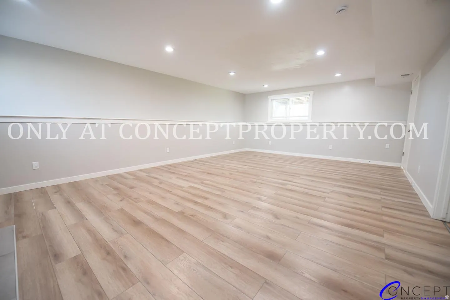 Recessed ceiling lighting, wood-finish flooring, white walls, white trim, and a window