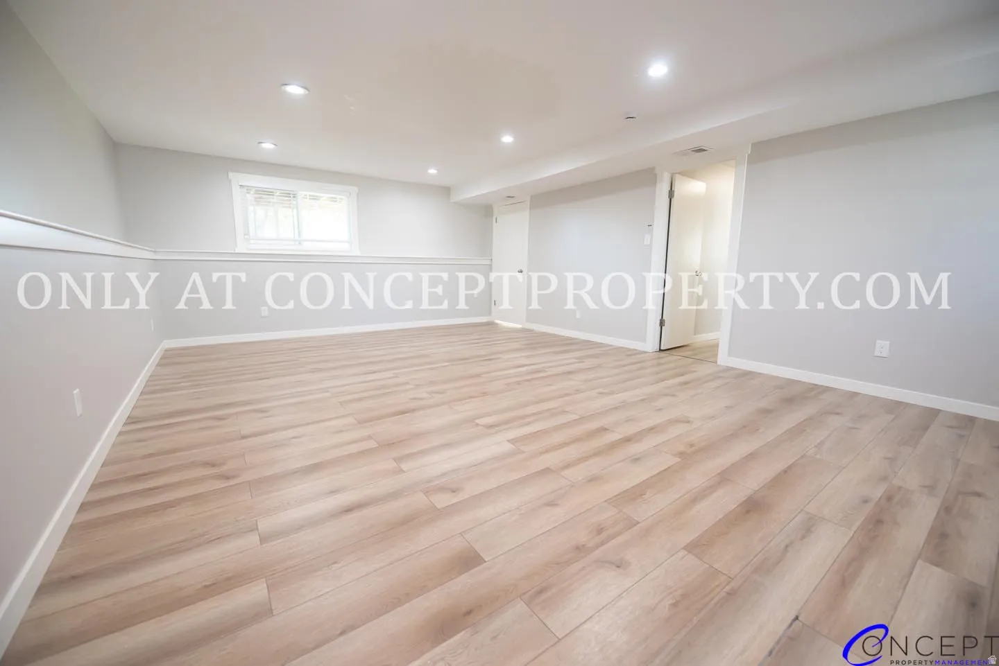 Recessed lighting, wood-finish flooring, half-wall wainscoting, and a window with white trim