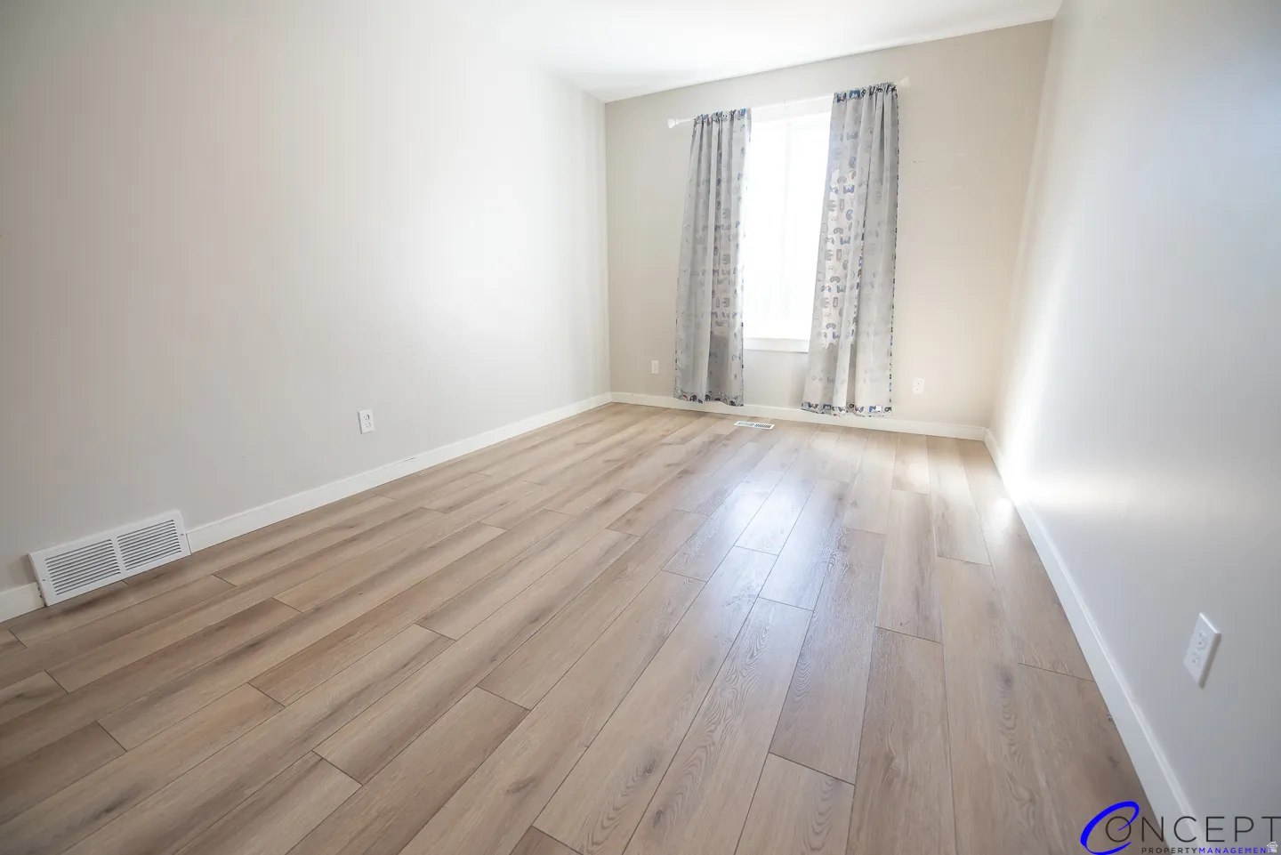 Wood-finish flooring, neutral wall tones, white trim, and a window with natural light