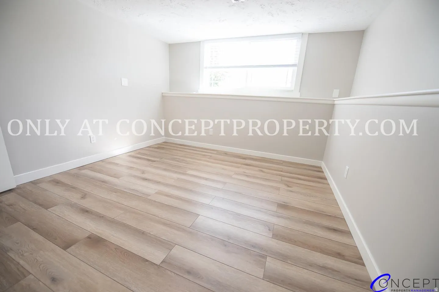 Wood-finish flooring with light-toned walls and a window