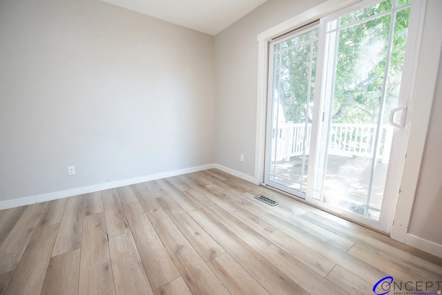 Light wood-finish flooring, neutral wall tones, and sliding glass door leading to an outdoor deck