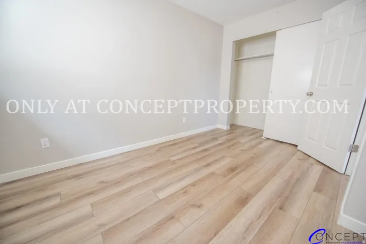Wood-finish flooring, light-toned walls, and a built-in closet with sliding doors