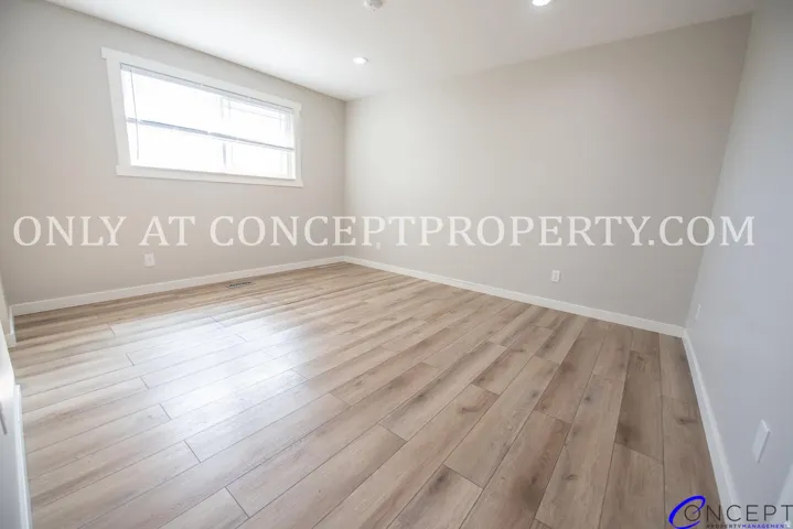 Light-toned wood-finish flooring, recessed lighting, and a white-trimmed window