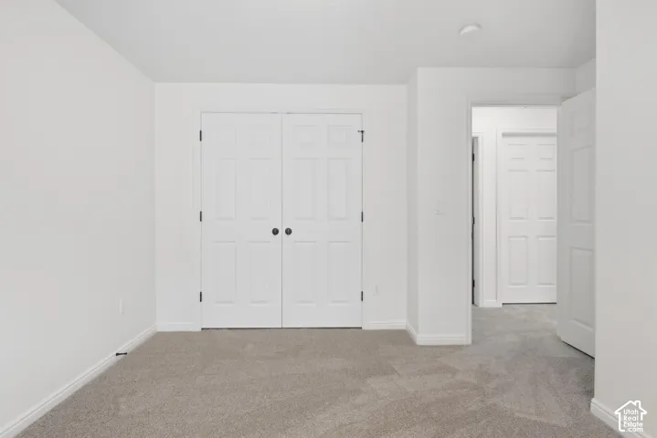 Neutral-toned carpeting, white interior doors, and a recessed ceiling light