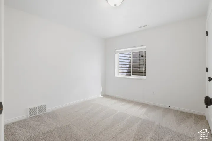 Neutral wall paint, recessed window with blinds, plush carpeting, and a flush mount ceiling light fixture