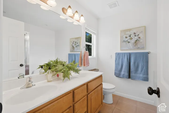 Double vanity with integrated sinks, wood-finish cabinetry, and a full-width mirror