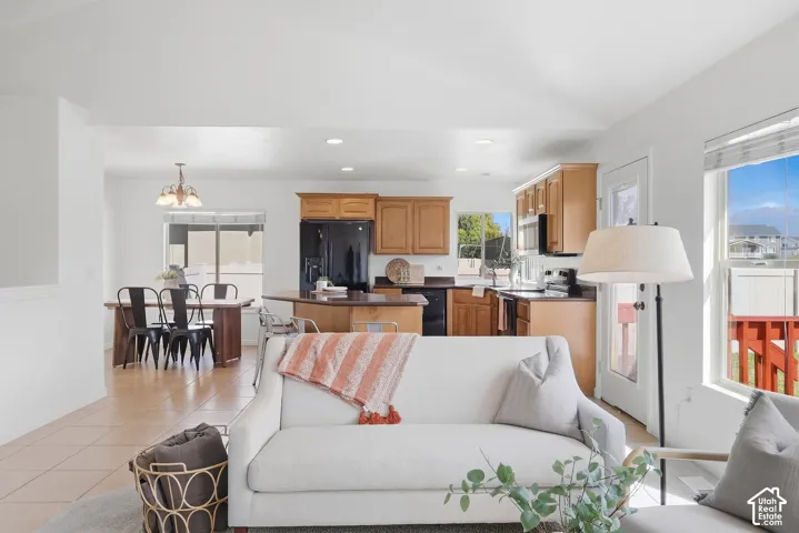 Open-concept living space with tile flooring, a kitchen island, and light wood cabinetry