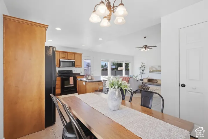 Integrated kitchen and dining area with wood-finish cabinetry, stainless steel appliances, and a central island