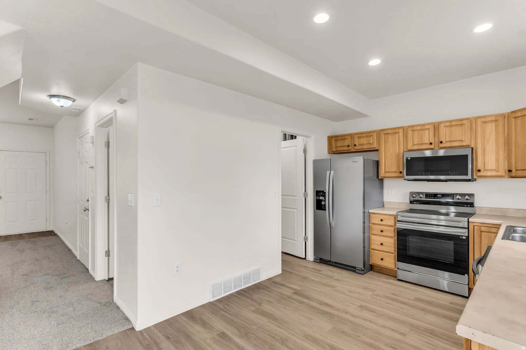 Kitchen featuring wood-finish flooring, recessed lighting, and stainless steel appliances