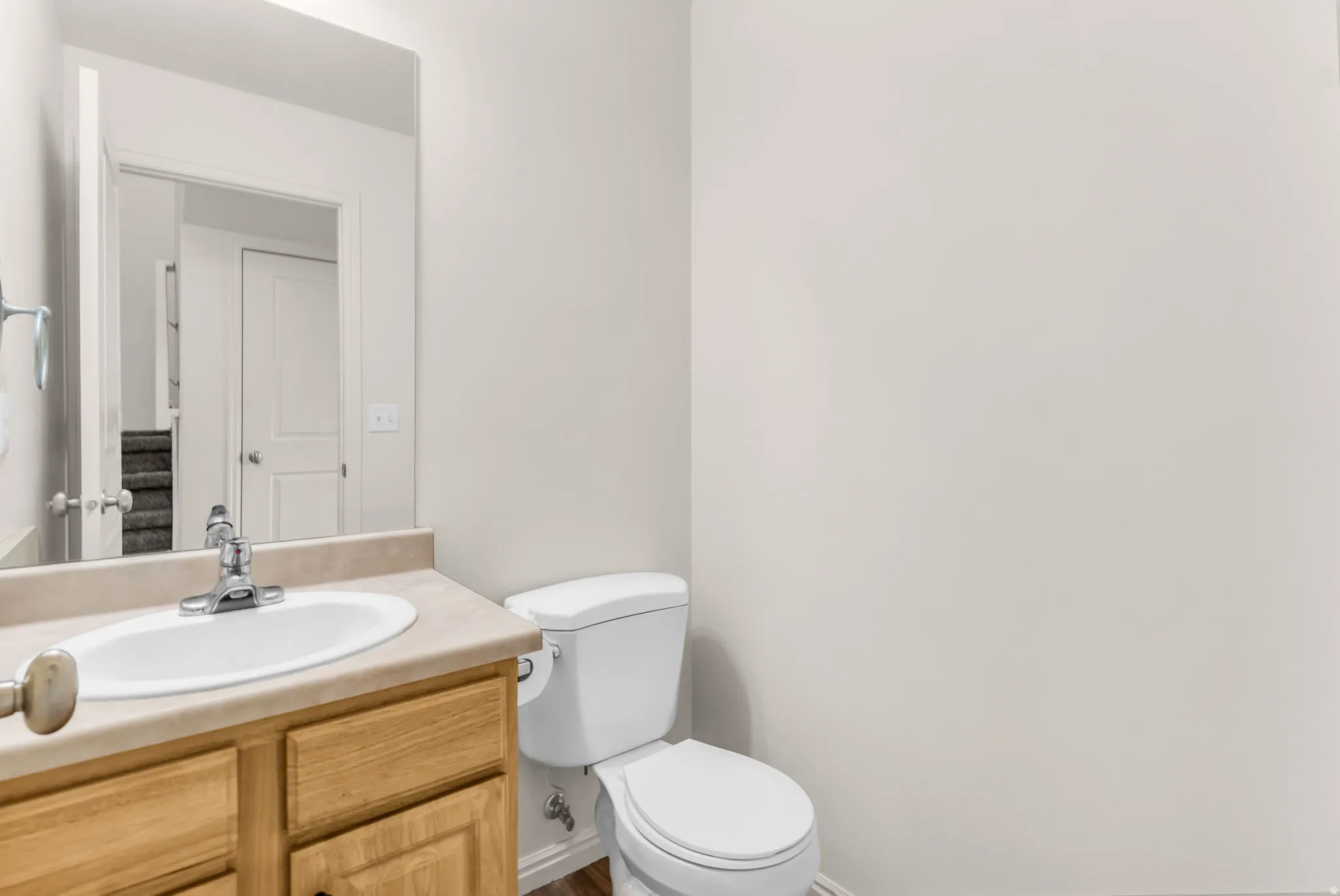 Wood-finish vanity with a drop-in sink, chrome faucet, and integrated mirror