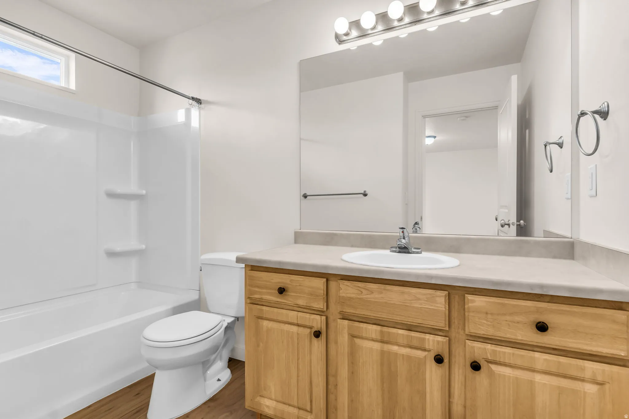 Full vanity with a single basin sink, wood-finish cabinetry, and an overhead vanity light fixture
