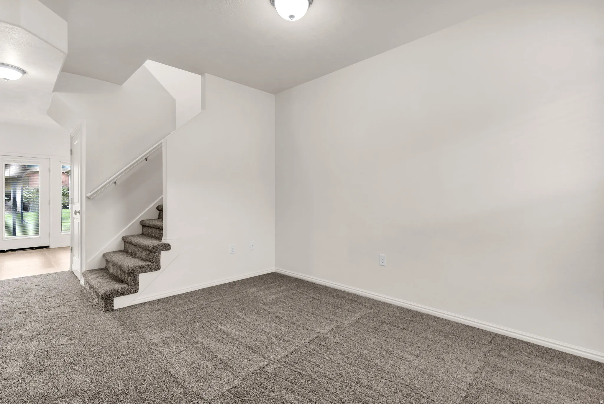 New carpet, white walls, white ceiling, white trim, and a white staircase with a contrasting handrail