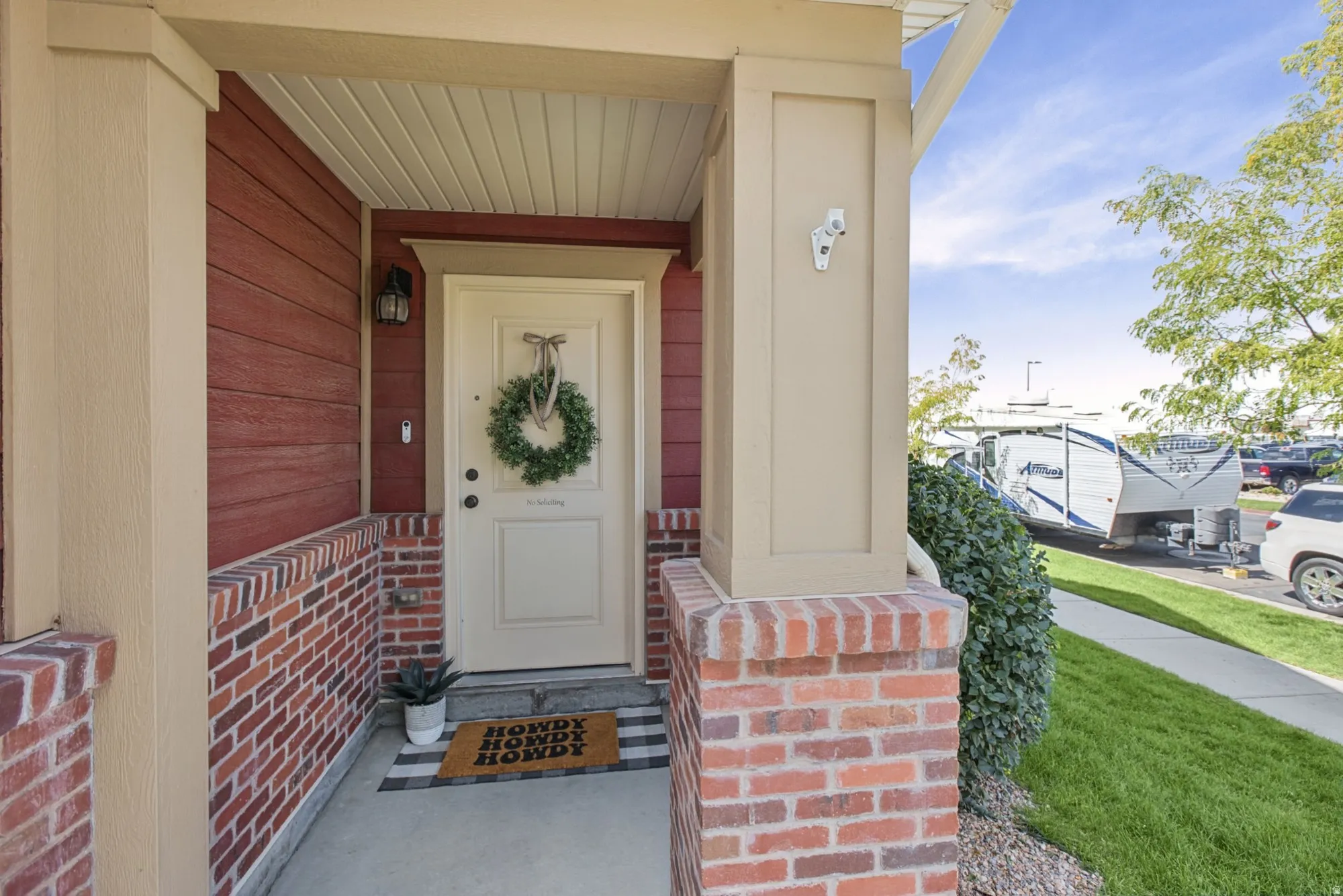 Covered front porch featuring brick and siding exterior