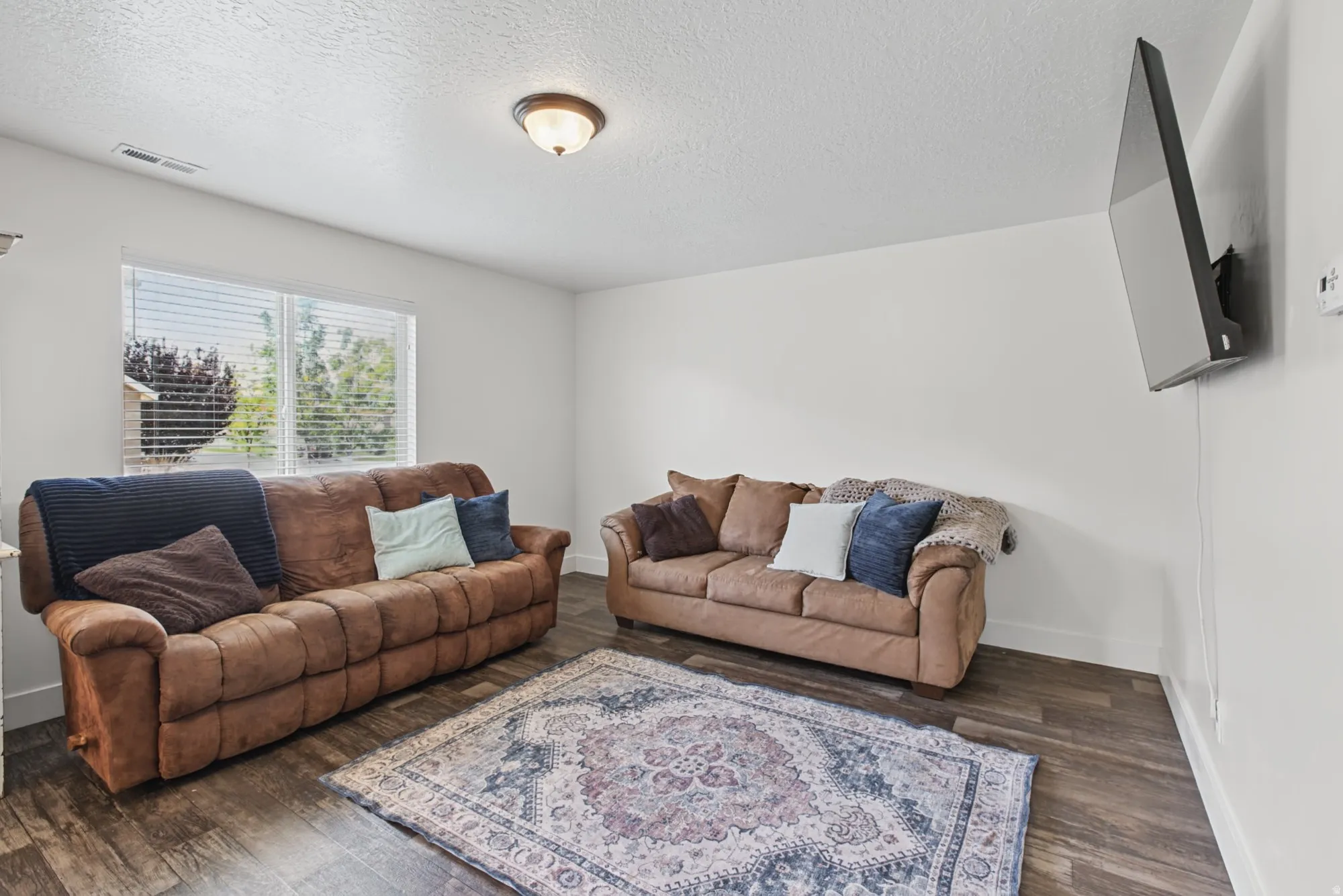 Wood-finish flooring throughout, white walls, and a recessed ceiling light