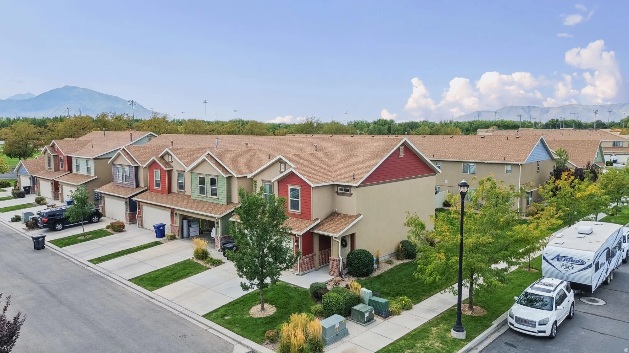Townhome-style residences featuring varied facade colors, attached garages, and individual entryways